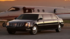 Image of black 8-10 passenger Lincoln Town Car stretch limousine next to a private airplane