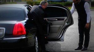 Image of chauffeur opening the door of a black CT Lincoln Town Car
